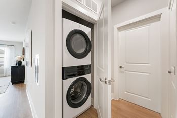 A modern laundry room with a washer and dryer built into the wall.